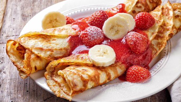 Palačinke sa svežim jagodama i bananama na drvetu